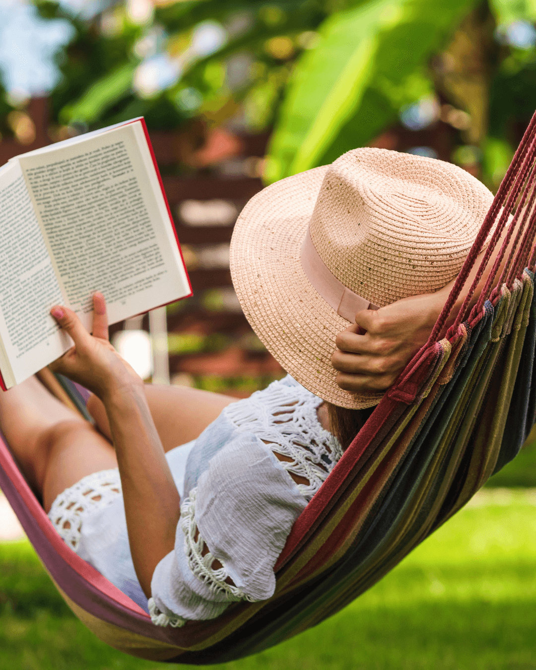 kvinna ligger i hammock och läser bok